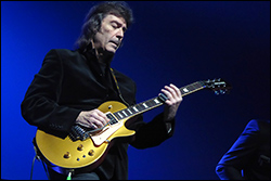 Steve Hackett Island. /></a>Steve hat dann noch bei zwei weiteren Todmobile-Songs Leadgitarre gespielt, bevor es als letztes Stück des regulären Sets The Lamb Lies Down On Broadway / The Musical Box (closing section) zu hören gab, mit dem bekannten Übergang zwischen den beiden Songs. Allerdings gab es kein richtiges Keyboard-Intro zu Lamb, sondern es setzte bereits mit der vollen Band ein. Das war dann vielleicht auch das einzige Genesis-Stück des Abends, das nicht so sehr vom Orchester profitieren konnte. Die zwei Zugaben waren Todmobile-Songs, aber Steve war wieder mit dabei.</p>
<p>Insgesamt haben sie zweidreiviertel Stunden gespielt und das Publikum war auch entsprechend begeistert, wobei der Isländer an sich ja eher nicht so temperamentvoll ist, aber es gab trotzdem jede Menge Applaus und irgendwann sind die Leute auch mal von ihren Sitzen aufgestanden.</p>
<p>Nach der Show wurden wir Backstage eingeladen und haben uns einige Zeit unter die Musiker gemischt. Auch Steve und Jo sind ziemlich lange geblieben und waren guter Dinge, denn es war alles ziemlich glatt gelaufen, ein voller Erfolg. Es gab auch einen schönen Kuchen mit angemessener Verzierung, wobei dort eigentlich ganz normal der Bandname Todmobile stehen sollte, was aber der Konditor kurioserweise völlig falsch verstanden hatte. Aber egal, Hauptsache die Genesis-Alben sehen korrekt aus!</p>
<p>
 <a src=